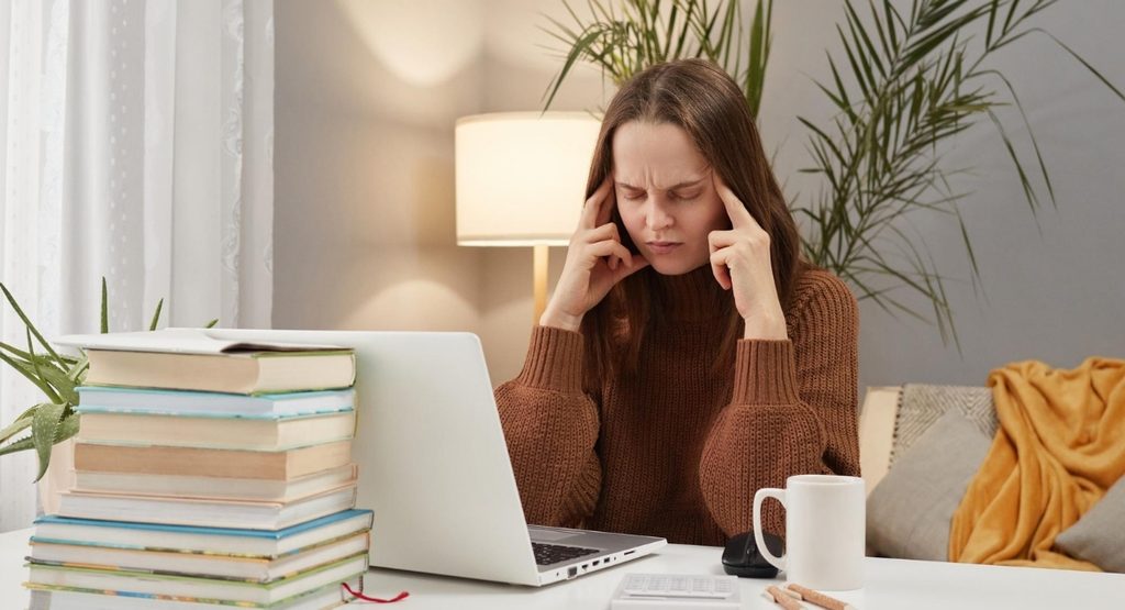 Woman experiencing difficulty concentrating while studying at home, representing ADHD symptoms in adults
