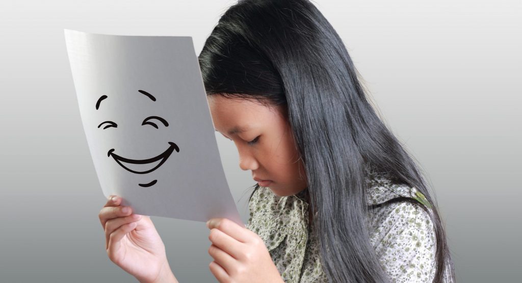Person smiling while experiencing hidden emotional distress from atypical depression.